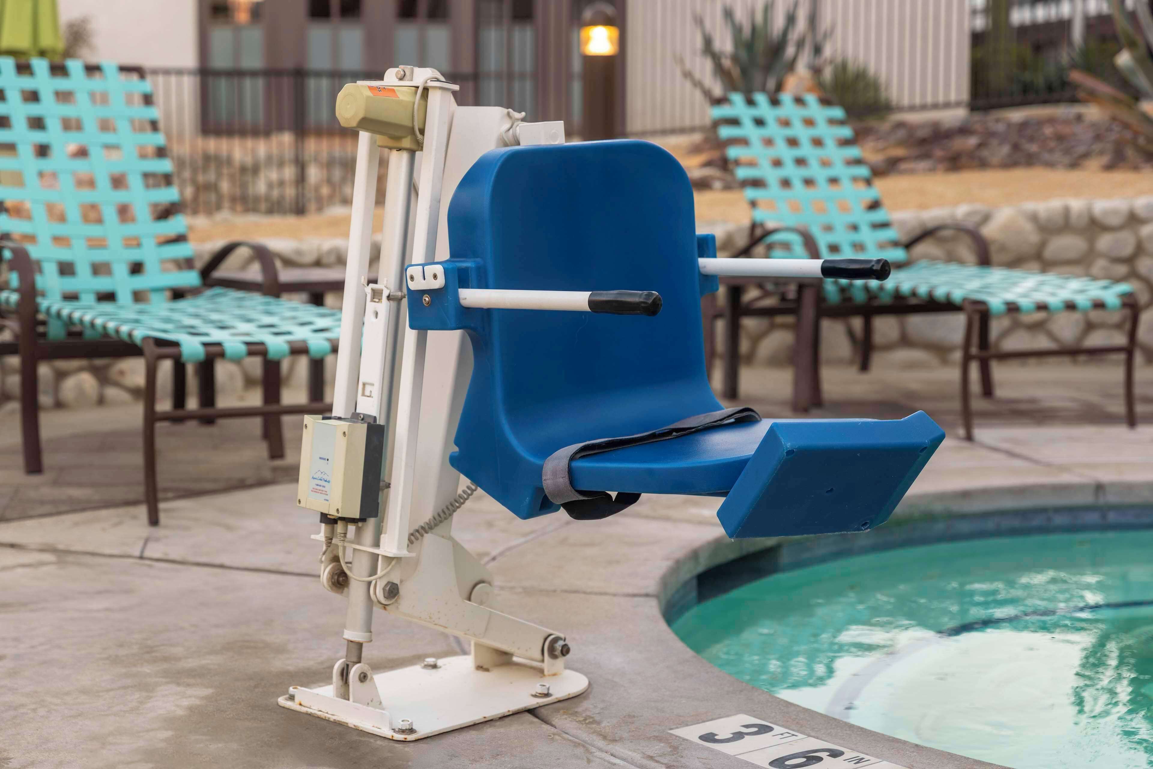 Una silla junto a la piscina, con asiento y respaldo azules, ubicada al lado de una pileta que indica una profundidad de 3.6 pies.