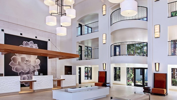 A spacious lobby with a central seating area, multiple balconies, and a large wall mural.