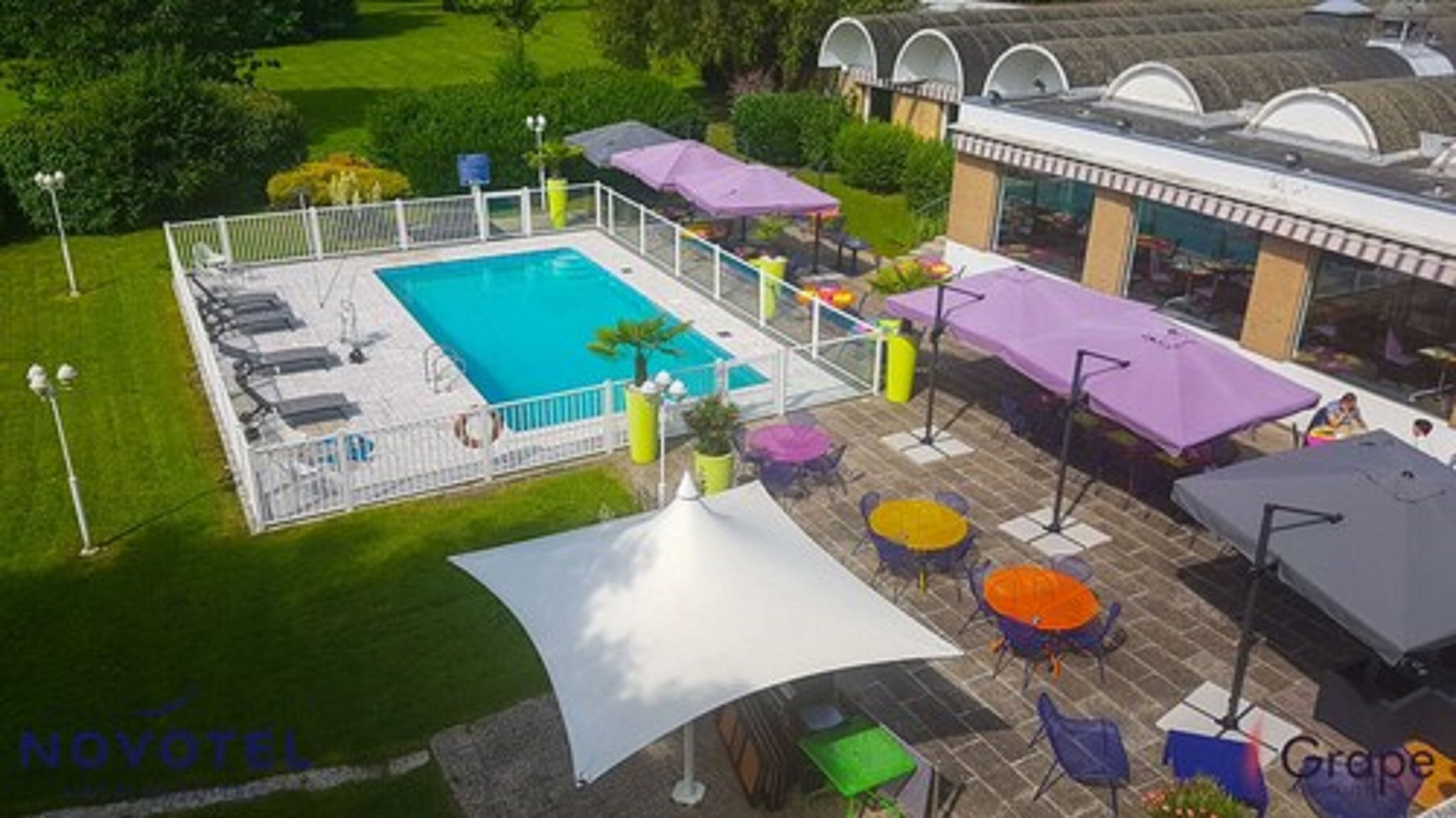 Un espace piscine équipé de chaises longues, de parasols et de mobilier d’extérieur.
