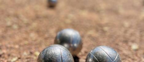 A close-up of four metallic balls on a gravel surface.