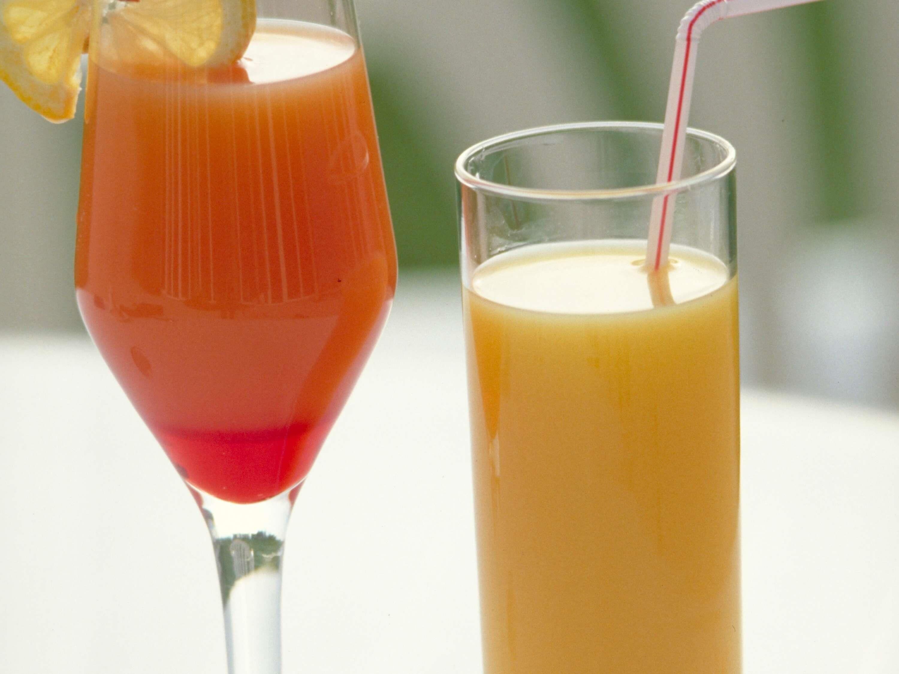 Dos vasos de bebidas, uno con una bebida roja y otro con una bebida amarilla, ambos con pajitas.