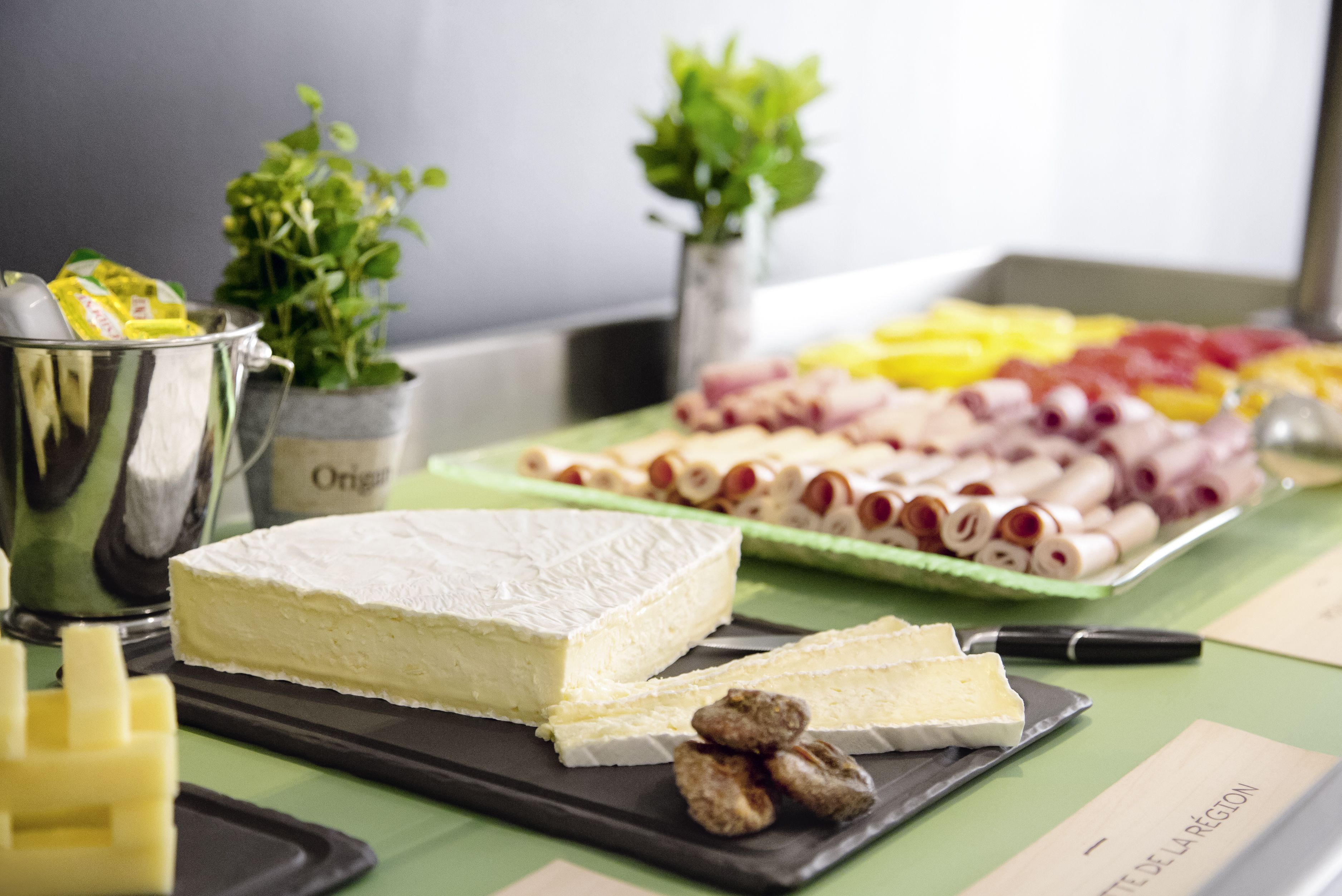 A cheese platter with various cheeses and accompaniments on a table.