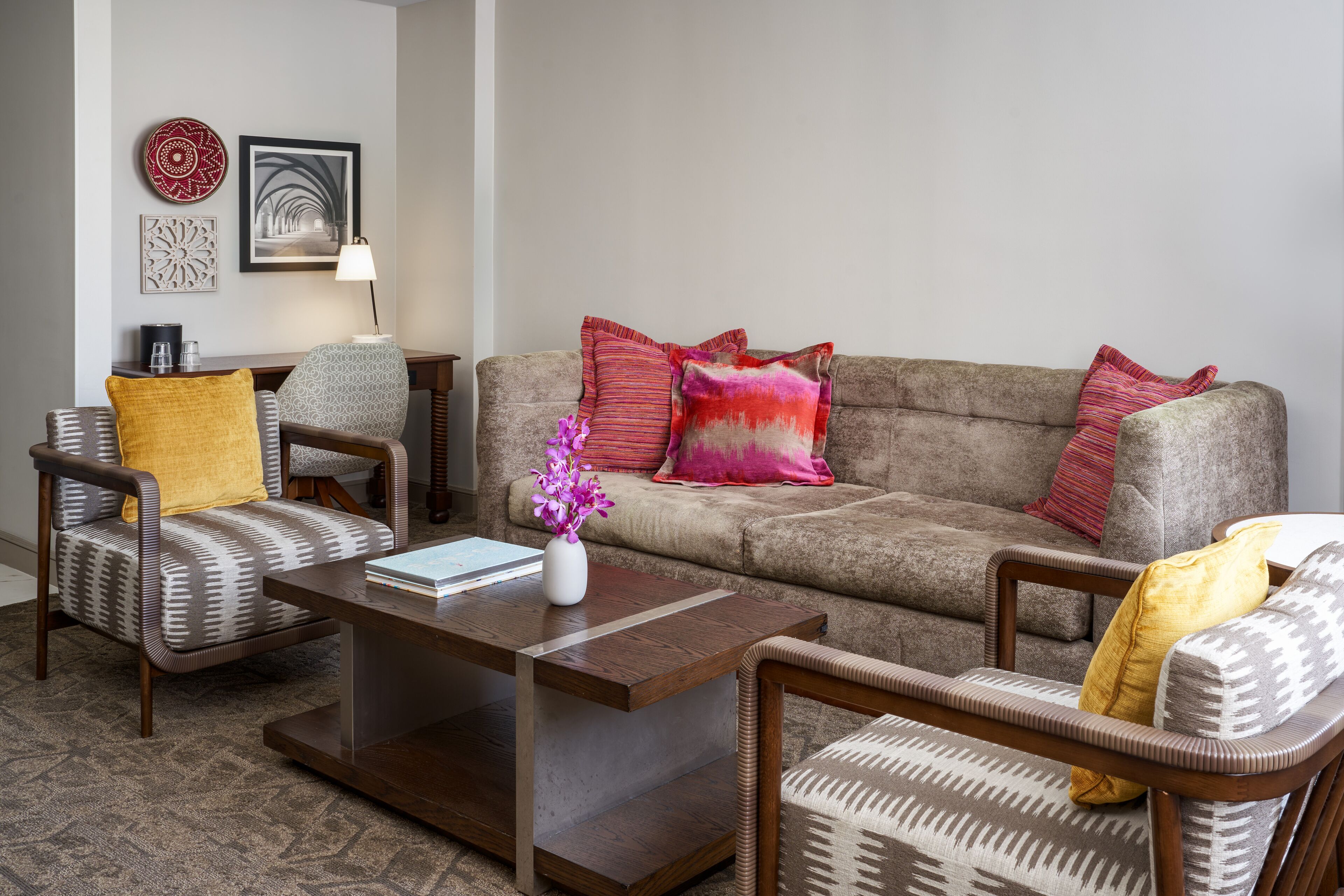 A living room with a sofa, two armchairs, a coffee table, and decorative pillows.