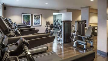 Une salle de sport équipée de tapis de course, de vélos elliptiques et d'appareils de musculation.