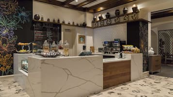 A modern bar area with a marble counter, a menu board, and various bar tools.