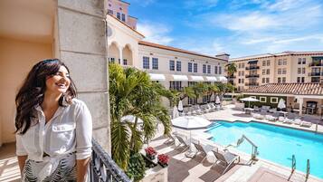 A hotel with a pool area, including lounge chairs and umbrellas.