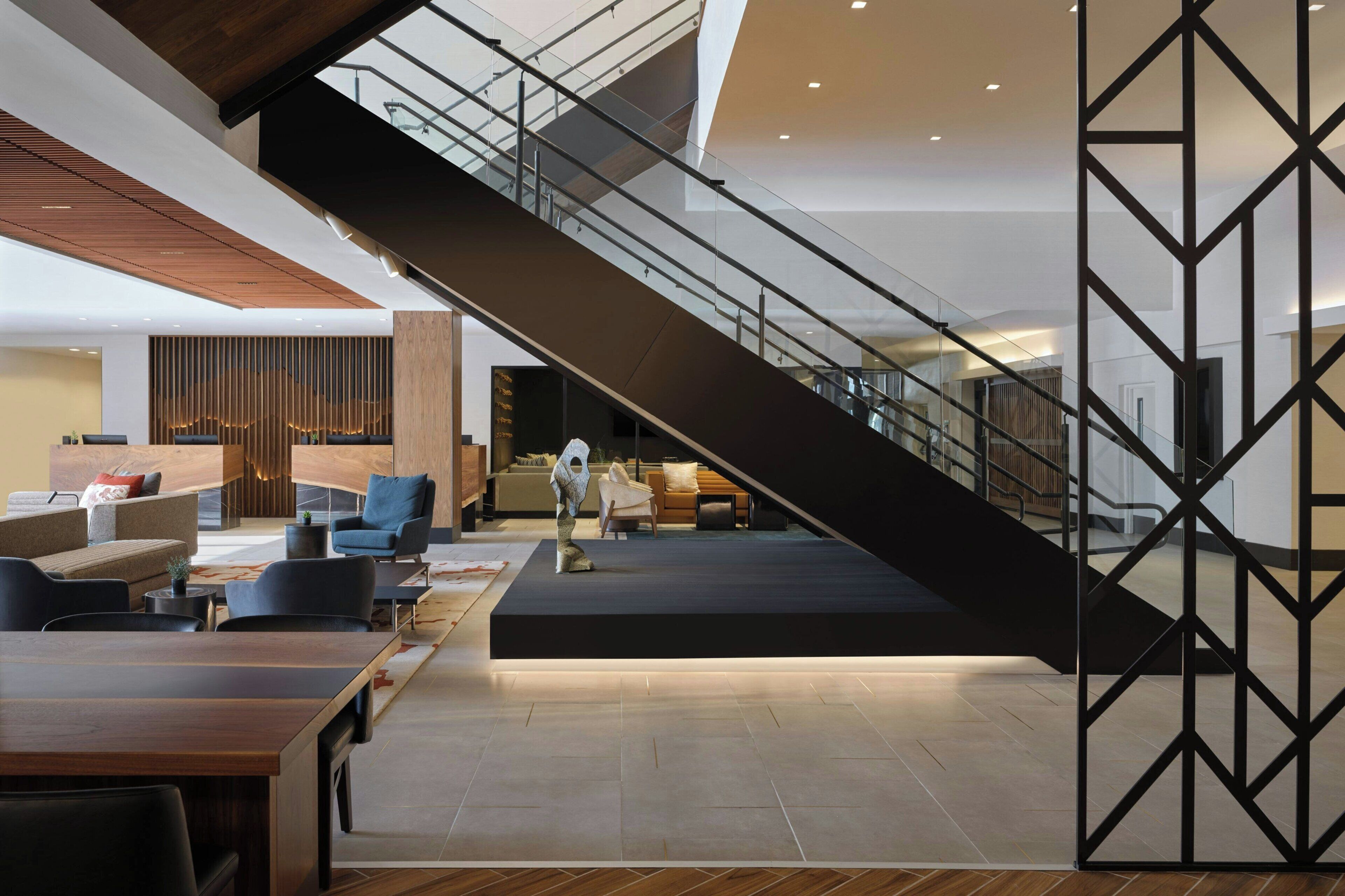 Un hall amplio con escaleras, zona de estar y mostrador de recepción.