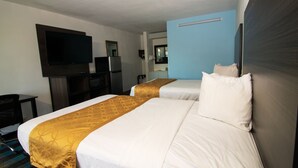 Quarto de hotel com duas camas, televisão, frigorífico e secretária.