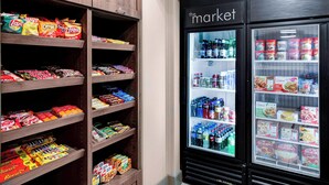 A snack and beverage section with shelves stocked with chips, cookies, and a refrigerated display with bottled drinks and boxed meals.