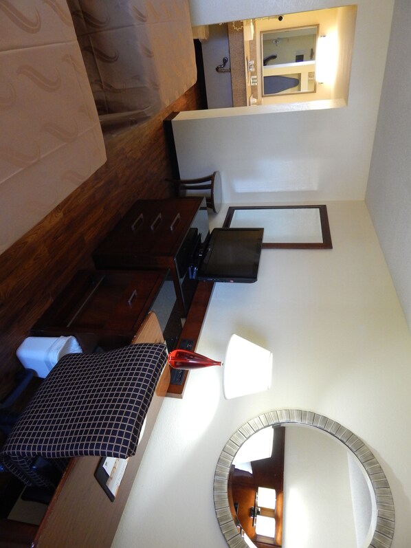 Simple, functional space with a small bed, nightstand, and chair.