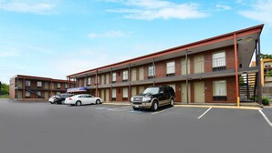 A motel with multiple floors, a parking lot, and several cars parked in front. - Americas Best Value Inn Nashville Downtown (Nashville)