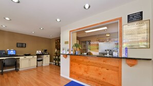 A reception area with a wooden counter, a blue mat with text, a sign indicating 'Manager on Duty', and a framed 'Motel Rules' notice. - Americas Best Value Inn Nashville Downtown (Nashville)