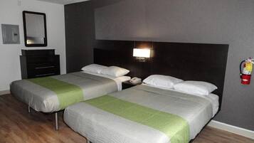 A hotel room with two beds, a nightstand, a mirror, a wall-mounted light, and a fire extinguisher.