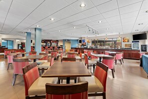 A spacious restaurant with multiple dining tables and chairs, a bar area, and a television screen. - Comfort Suites Bethlehem Near Lehigh University and LVI Airport (Bethlehem)