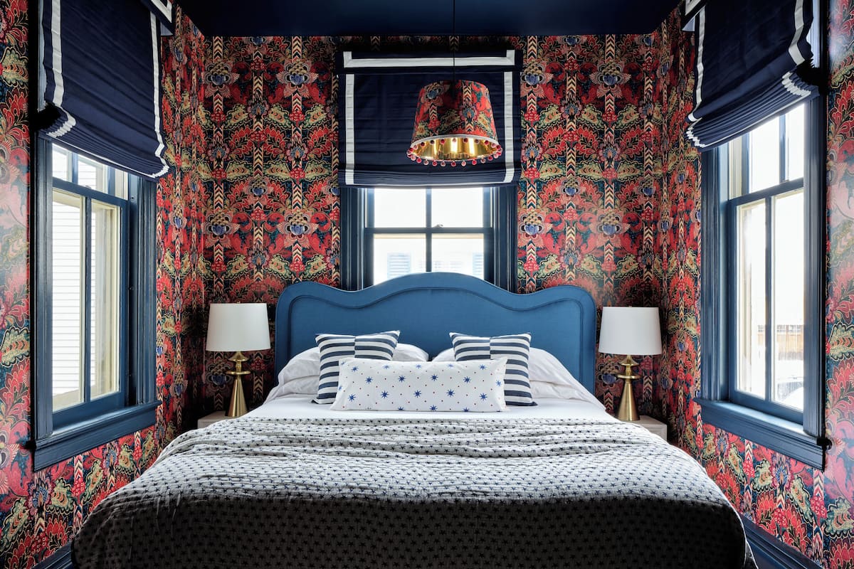 Un dormitorio con una cama grande, dos mesitas de noche y una ventana con cortinas.