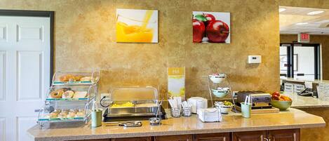 A breakfast bar with various food items and a coffee machine.