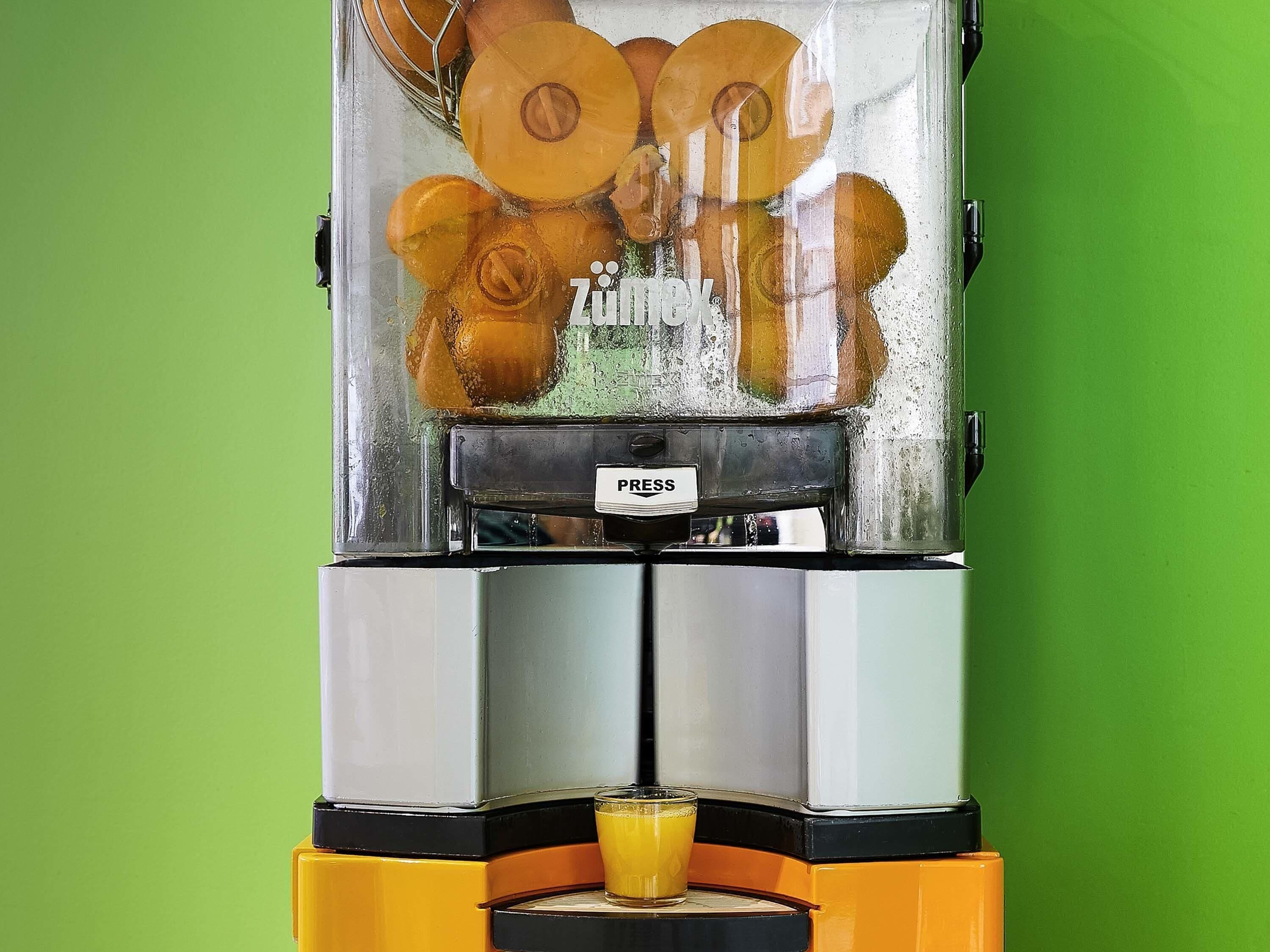 A vending machine with a 'PRESS' button, dispensing orange slices.