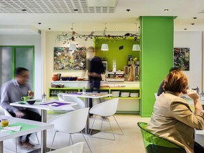 A modern cafe with green walls, white furniture, and a variety of food and drink options. - ibis Styles Lille Centre Gare Beffroi (Lille)