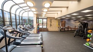 Una palestra con tapis roulant, palle da ginnastica e un murale.