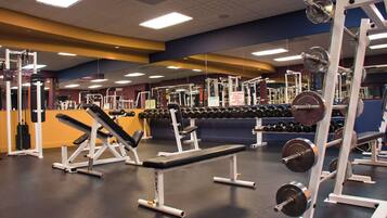 A gym with various exercise equipment, including benches and weight racks.
