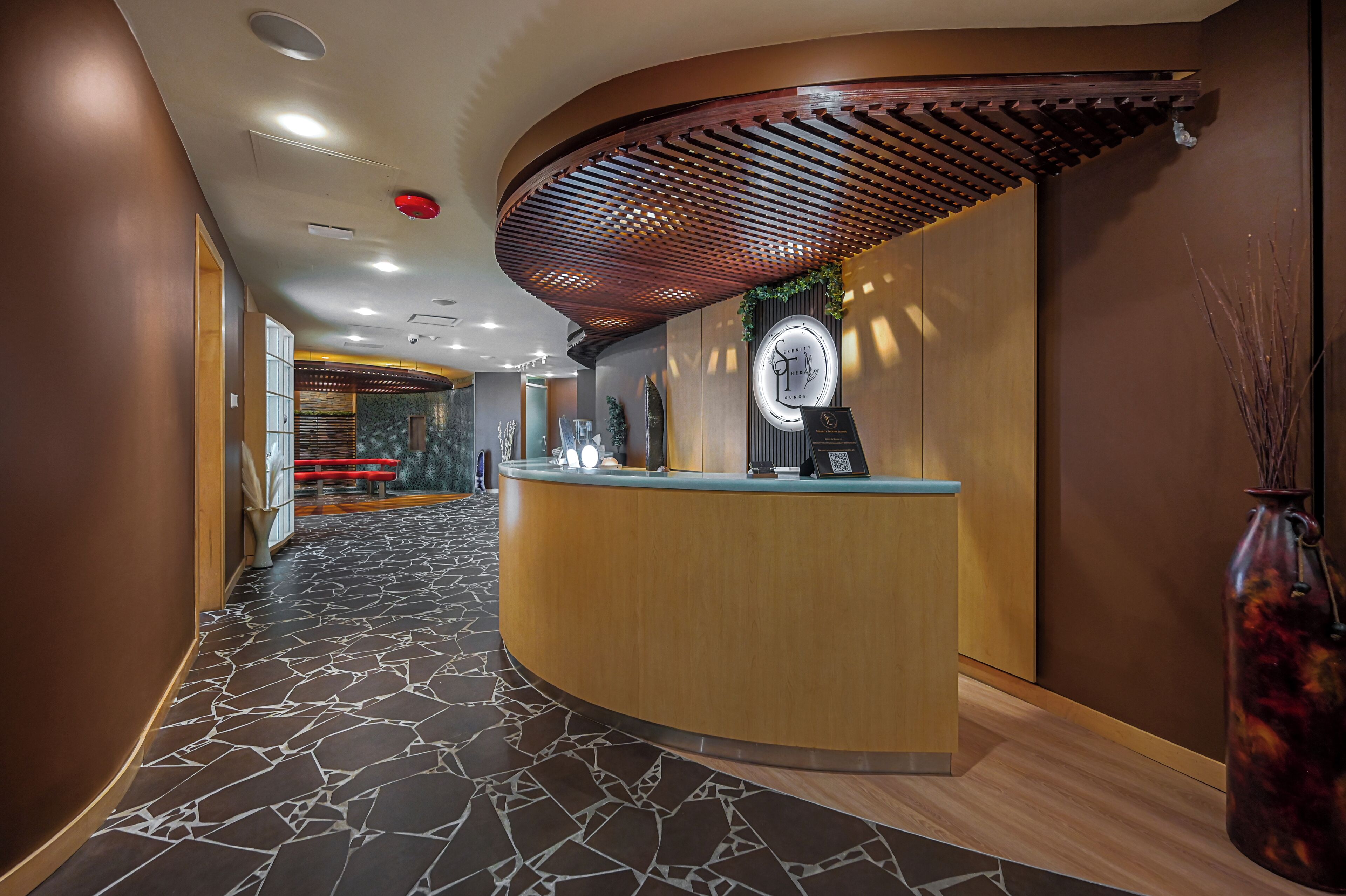 A reception area with a curved wooden counter, a reception desk, and a patterned floor.