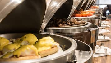 Een buffet met diverse gerechtjes, waaronder eieren Benedict en geroosterde aardappelen.