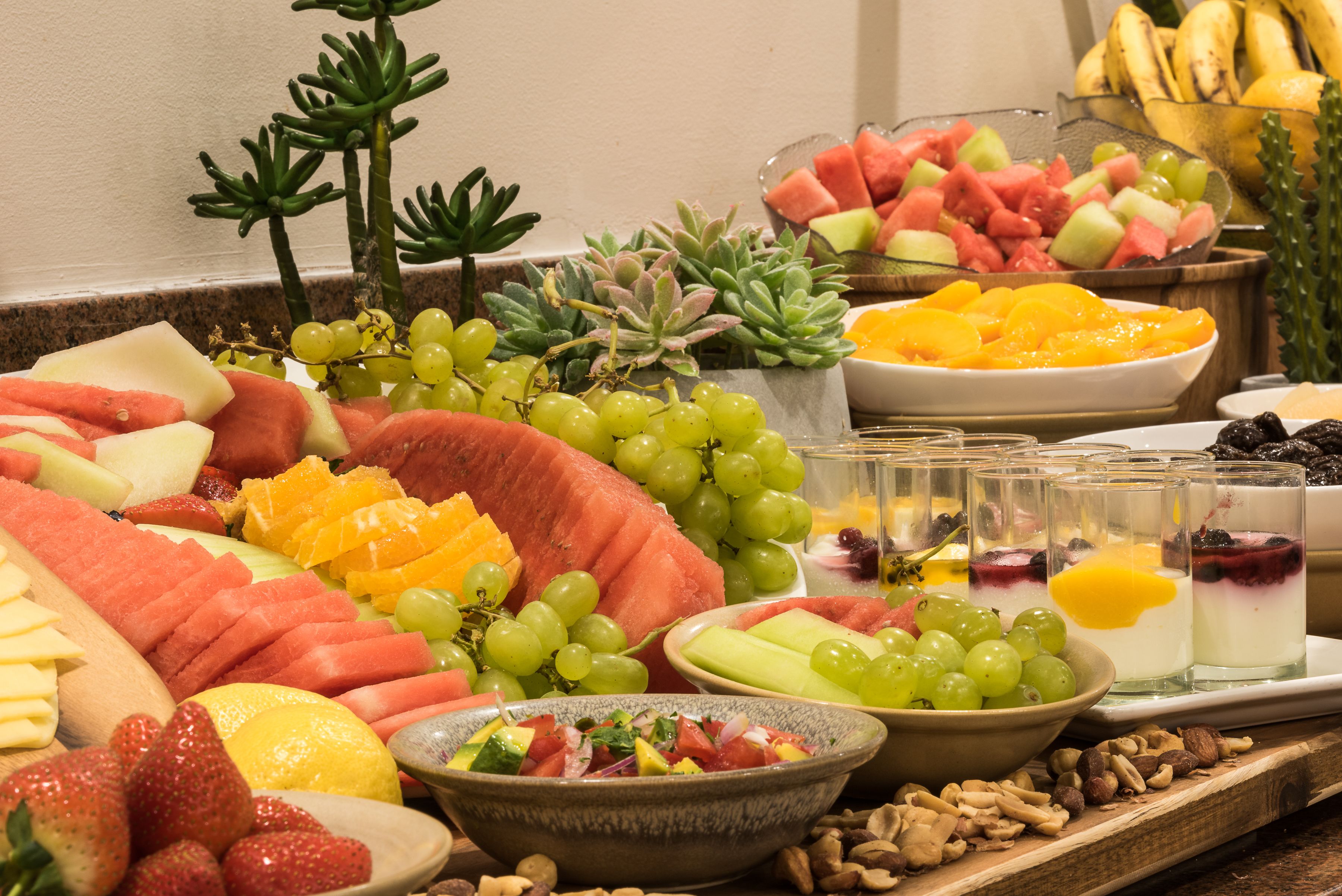 A fruit and cheese platter with various fruits, cheeses, and nuts.
