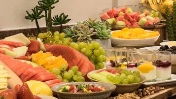 A fruit and cheese platter with various fruits, cheeses, and nuts.