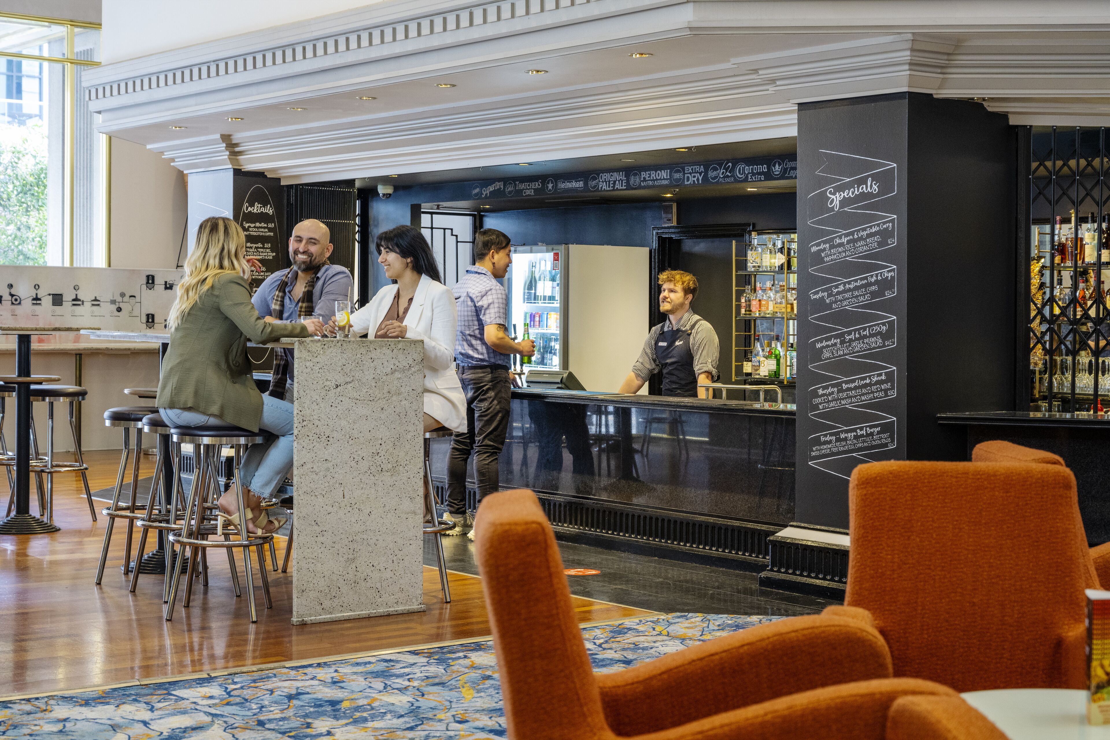 A bar area with stools, a counter, and a menu board listing specials.