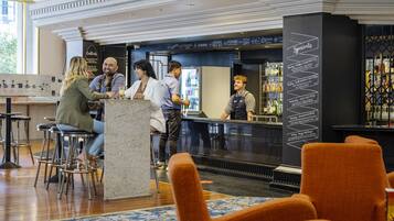 A bar area with stools, a counter, and a menu board listing specials.
