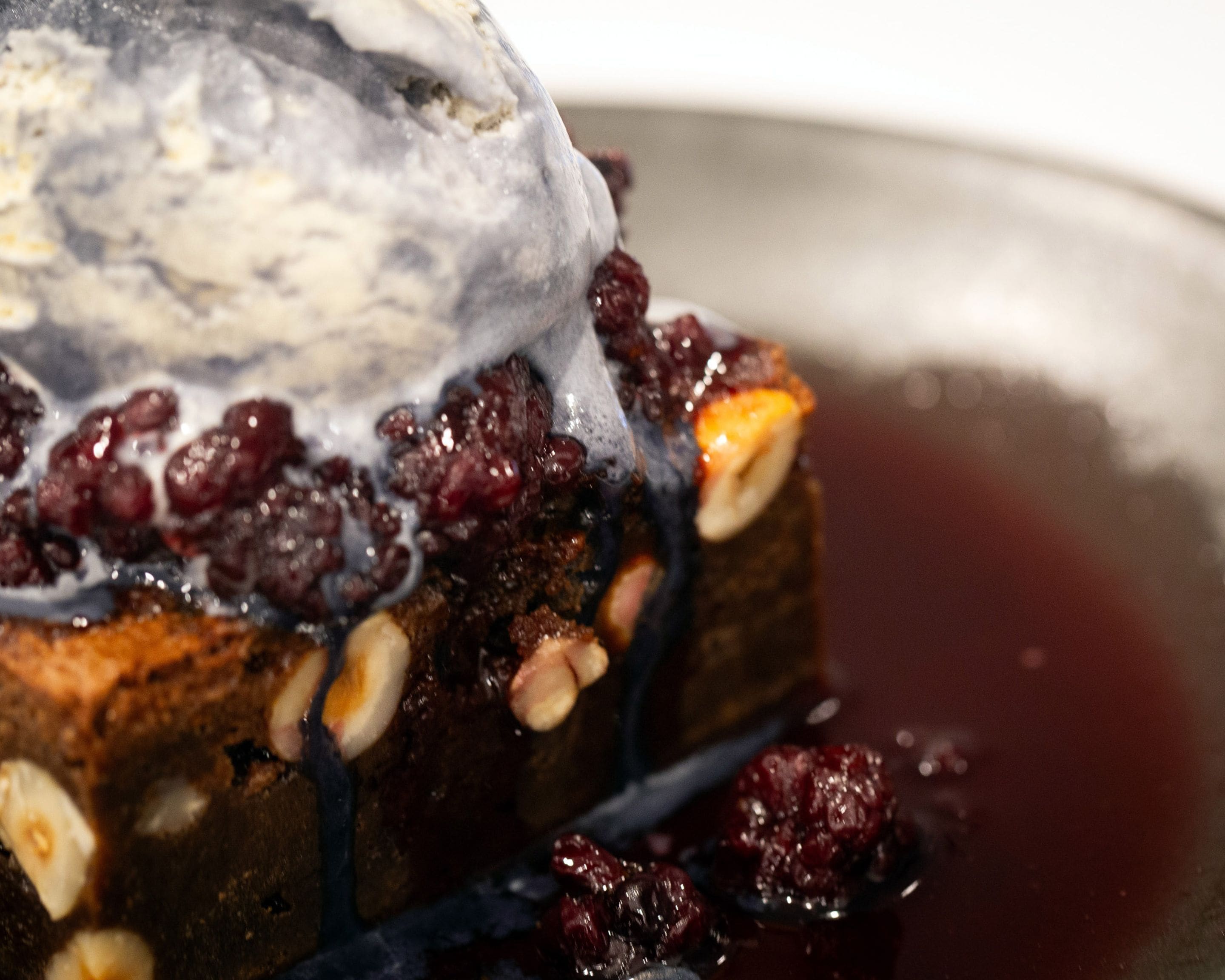 A dessert with berries and nuts on a plate.