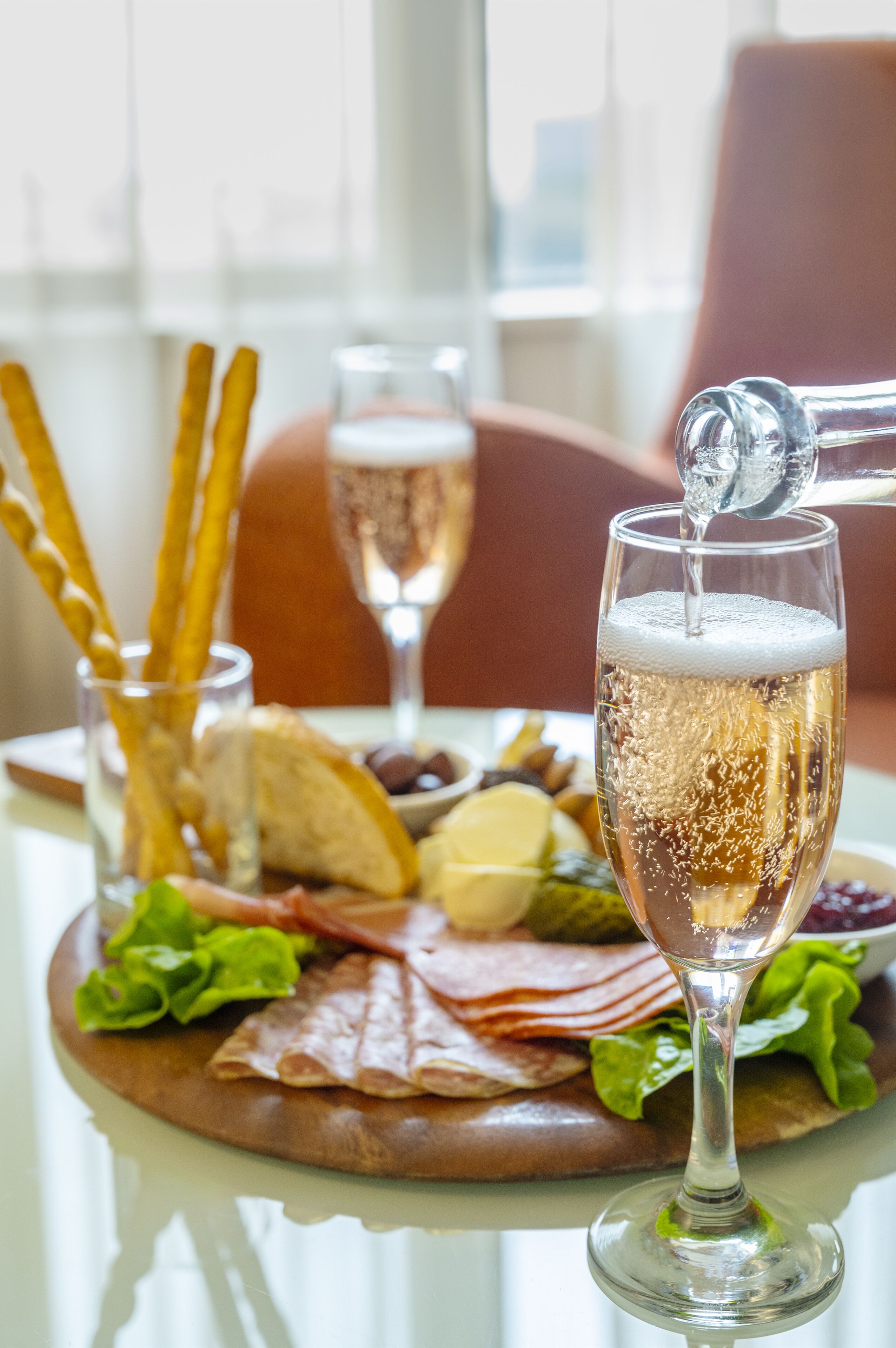 Een tafel met een glas champagne, een bord eten en een glas bier.
