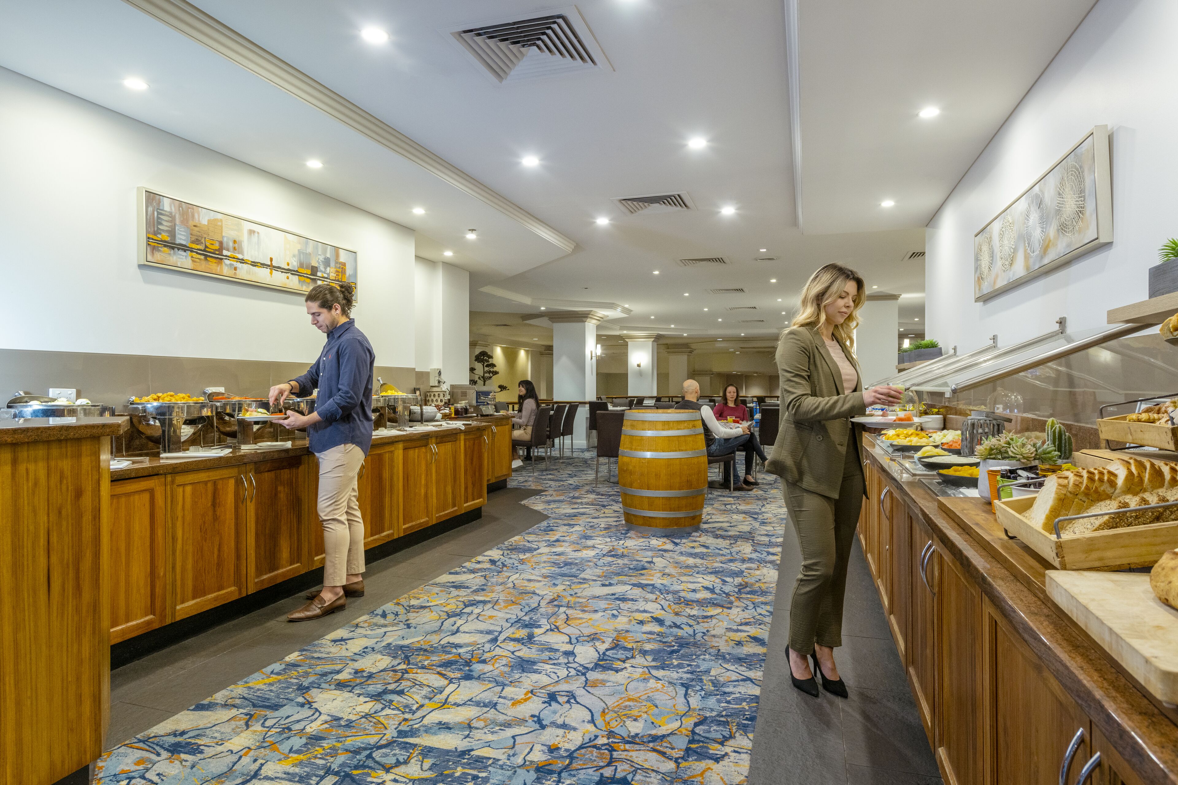 A buffet area with wooden counters, a patterned carpet, and artwork on the walls.
