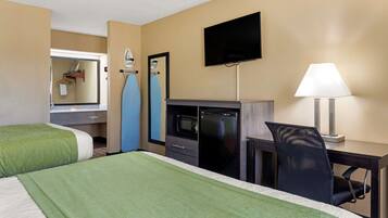 A hotel room with two beds, a desk with a chair, a television, a microwave, and a mirror.