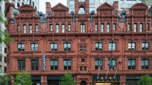 A red brick building with ornate architectural details, multiple windows, and a storefront at the ground level. - The Goodwin Hotel (Hartford)