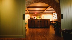A lobby with a brick archway, wooden flooring, and a reception desk. - The Goodwin Hotel (Hartford)
