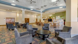 A spacious lobby with grey armchairs, a central round table, and ceiling fans. - Best Western Plus Loveland Inn (Loveland)