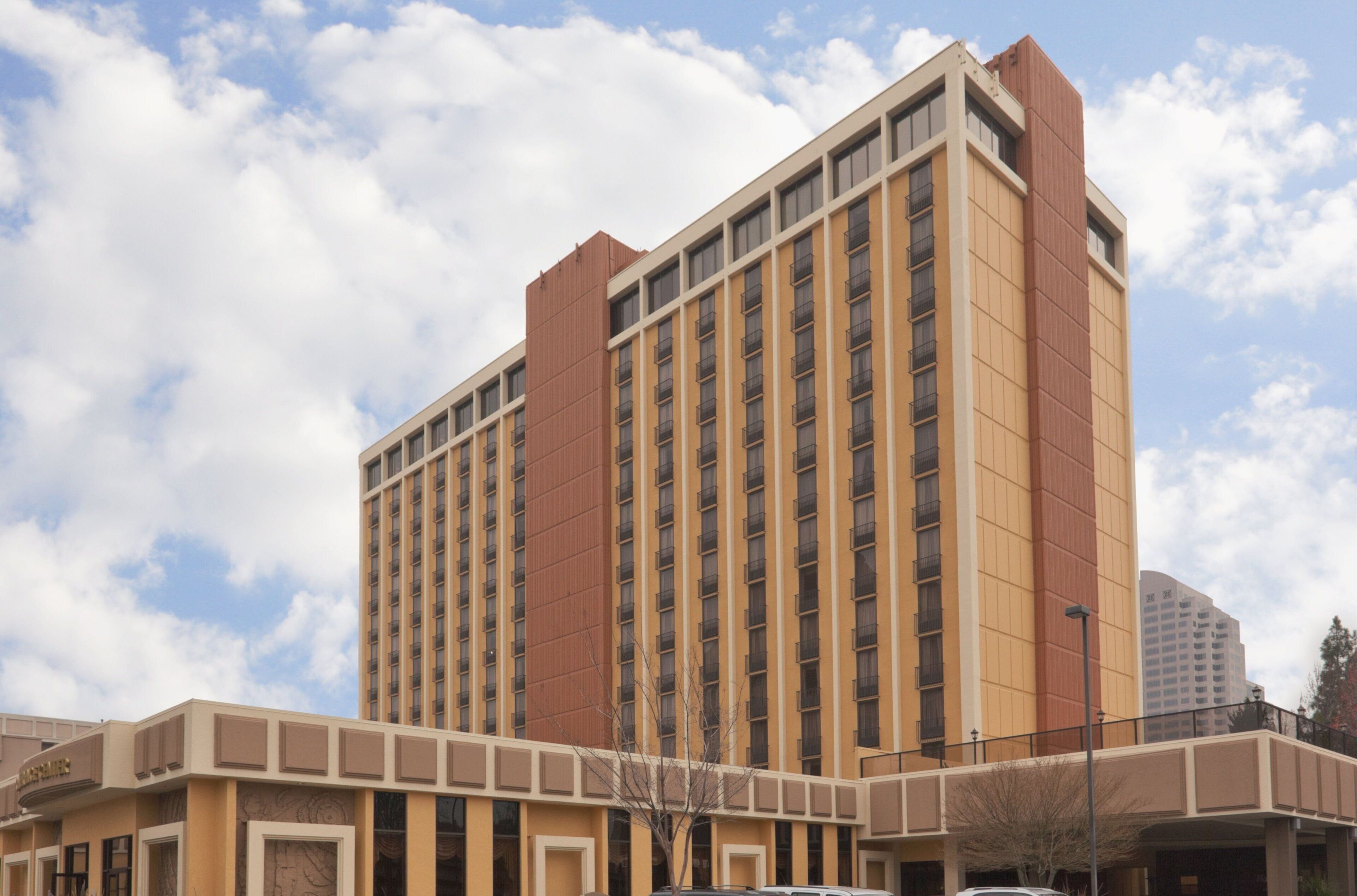 Un hotel de varios pisos con una torre central y una edificación de techo plano en la base.
