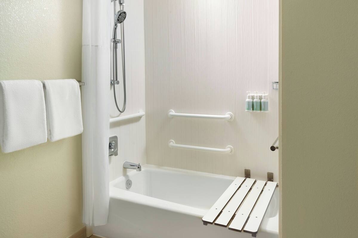 Un baño con bañera, ducha y toallero.