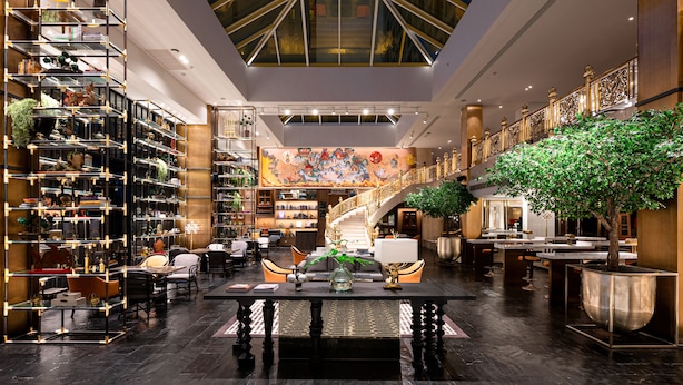 A spacious lobby with a high ceiling, a grand staircase, and a large mural. - Montien Hotel Surawong Bangkok (Bangkok)