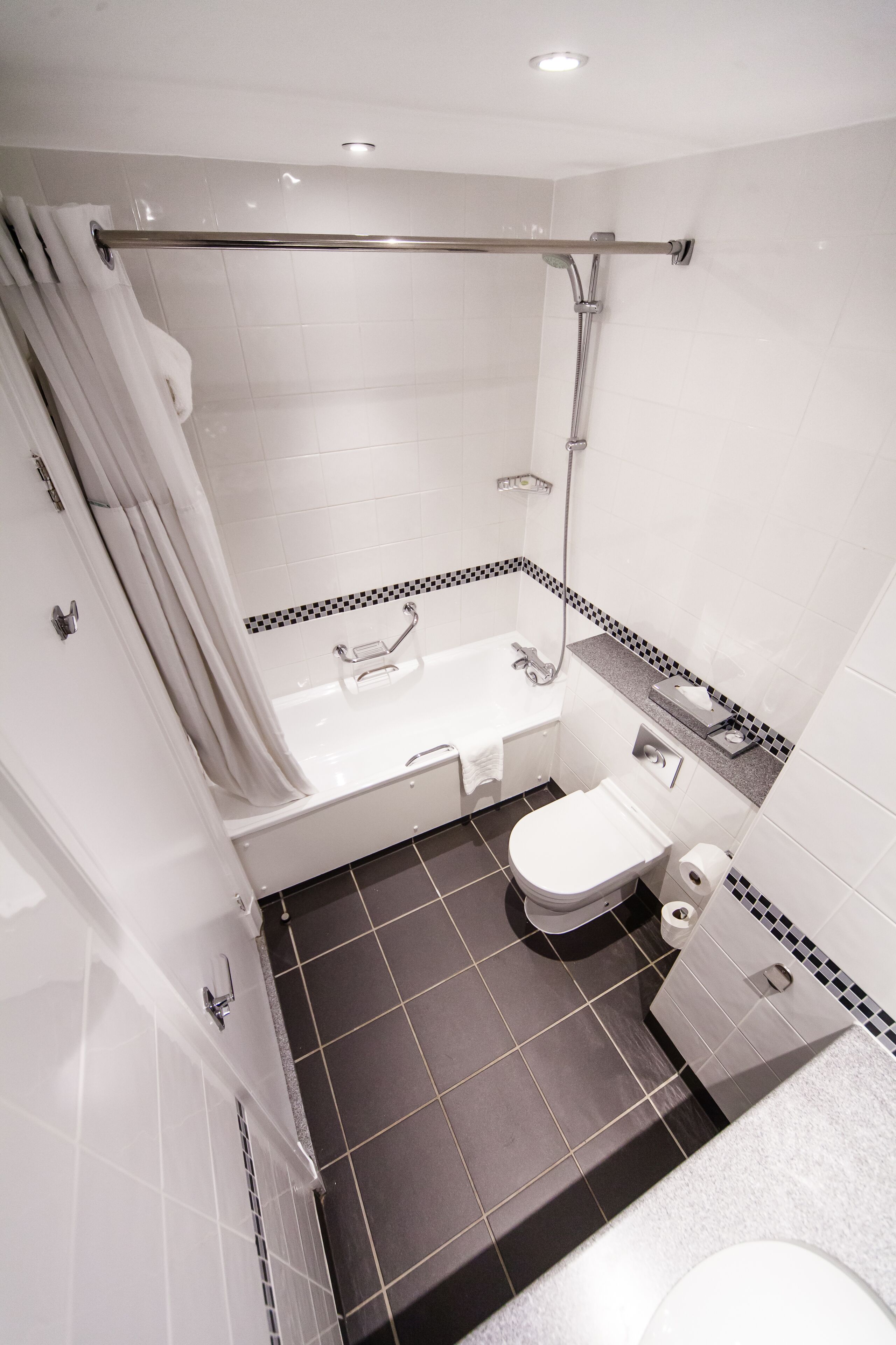 A bathroom with a bathtub, toilet, and shower.