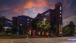 A hotel with a prominent tower, multiple windows, and a well-lit facade. - Crowne Plaza Leeds by IHG (Leeds)