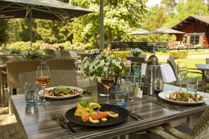 An outdoor dining area with tables, chairs, and umbrellas. - Fletcher Hotel - Restaurant De Wipselberg - Veluwe (Beekbergen)