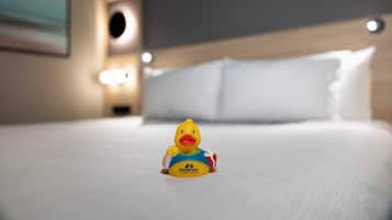 Una cama con una figurita de pato encima.