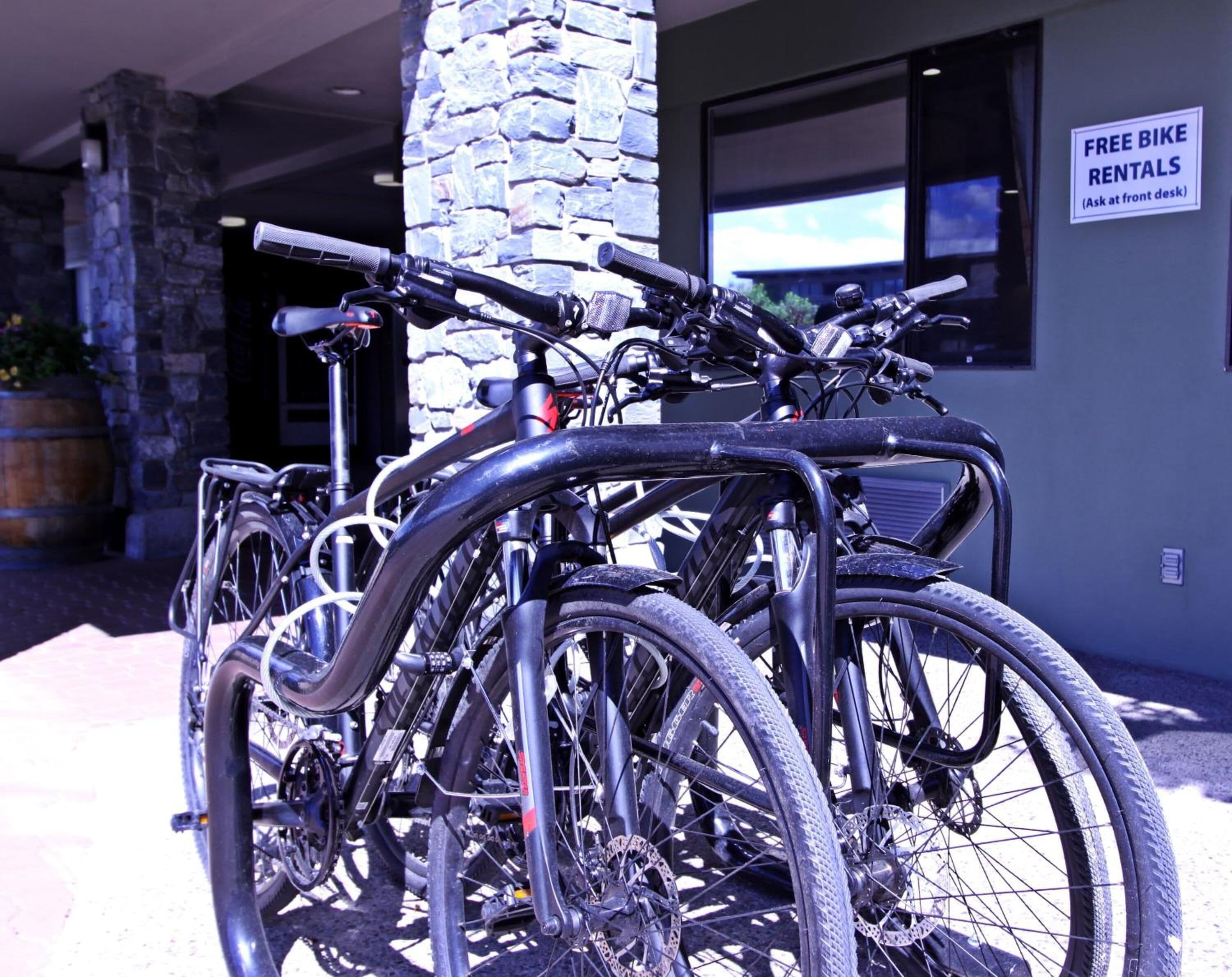 Une rangée de vélos est garée devant un bâtiment sur lequel est apposée une enseigne indiquant que des vélos peuvent être loués gratuitement.