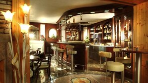 A bar area with a polished marble floor, wooden accents, and bar stools. - Airporthotel Salzburg (Salzburg)