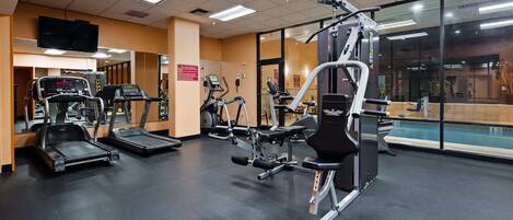 Ein Fitnessstudio mit Laufbändern, Crosstrainern und Gewichten.