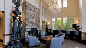 A spacious lobby with a stone fireplace, comfortable seating, large windows, and a chandelier. - Elm Hurst Inn & Spa, WorldHotels Crafted (Ingersoll)