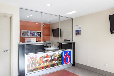 A reception desk with a large sign reading "We'll leave the light on for you."