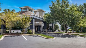 A modern building with a flat roof, large windows, and a parking lot in front. - Quality Inn near MCAS Cherry Point (Havelock)